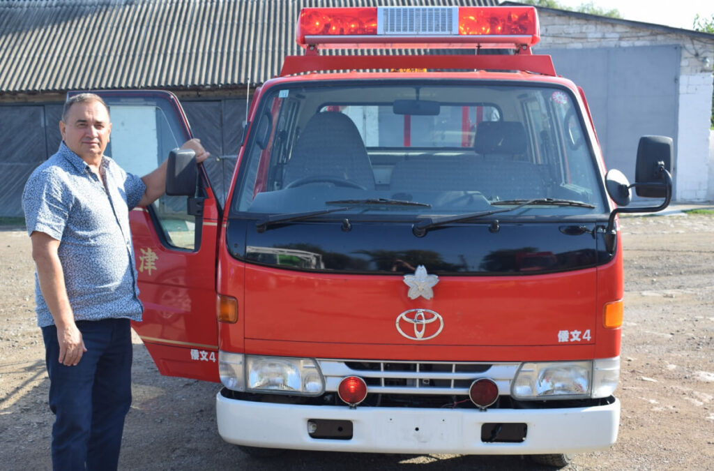 トヨタ製の赤い消防車と寄贈を喜ぶ現地住民